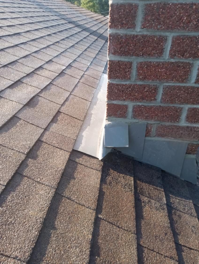 A close up of a roof with a chimney on it.