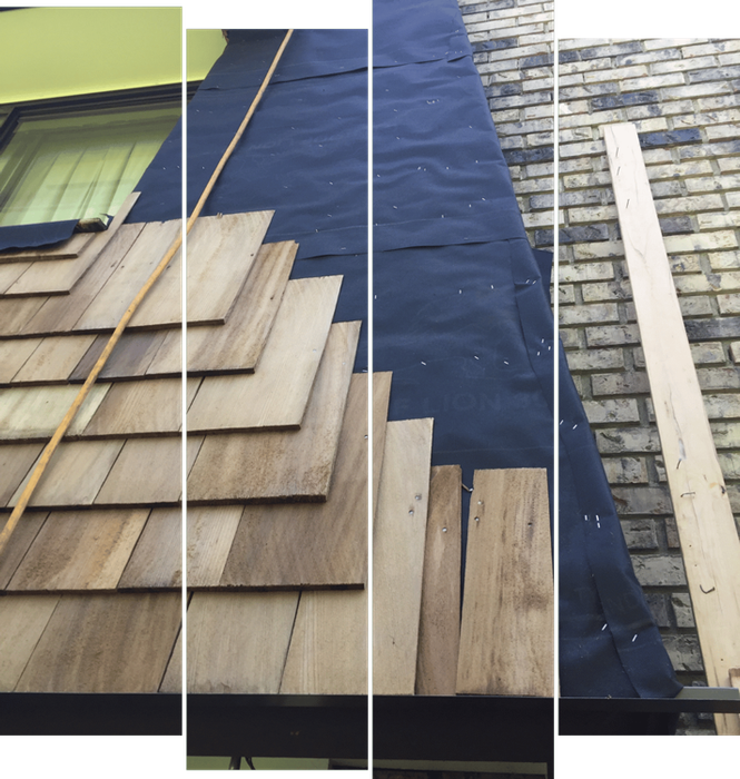 A wooden roof is being installed on a brick building