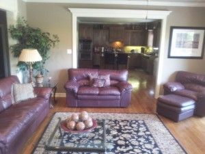 A living room with a couch , chair , coffee table and rug.