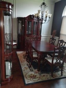 A dining room with a table and chairs and a rug.