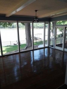 An empty room with a lot of windows and a view of a lake.