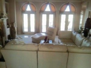 A living room with white furniture and arched windows.