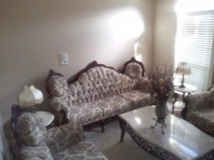 A living room with a couch and chairs and a coffee table