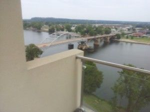 A balcony with a view of a river and a bridge.