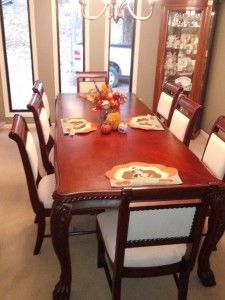 A dining room table with chairs and a chandelier.