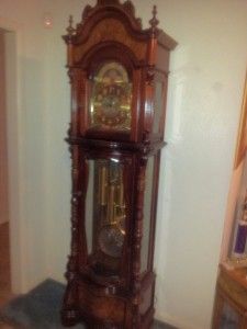 A large grandfather clock is sitting on a table in a room.