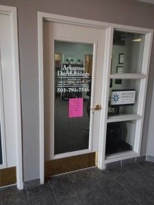 A door with a pink sign on it is open to a dental office.