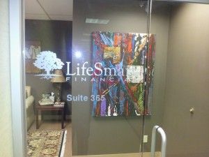 A room with a glass door and a painting on the wall.