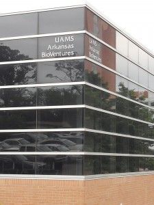 A large building with a lot of windows and a lot of cars parked in front of it.