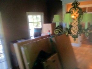 A living room filled with boxes and a chandelier.