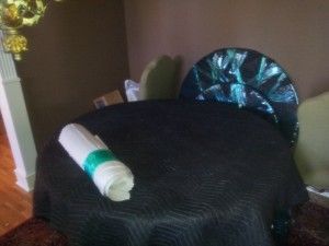 A table with a black table cloth and a roll of paper on it.