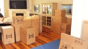 A living room filled with lots of cardboard boxes.