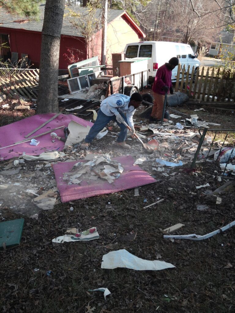 A group of people are cleaning up a messy yard