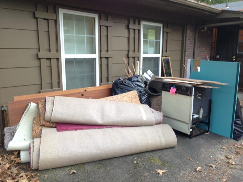 A pile of garbage is sitting in front of a house.