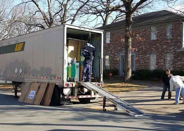A man is loading boxes into a moving truck.