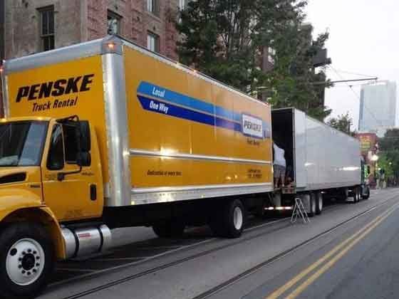 A penske truck is parked on the side of the road
