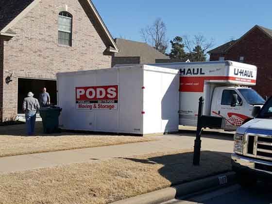 A pods moving and storage truck is parked in front of a house