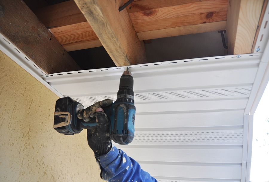 A person is painting a wall blue with a paint roller