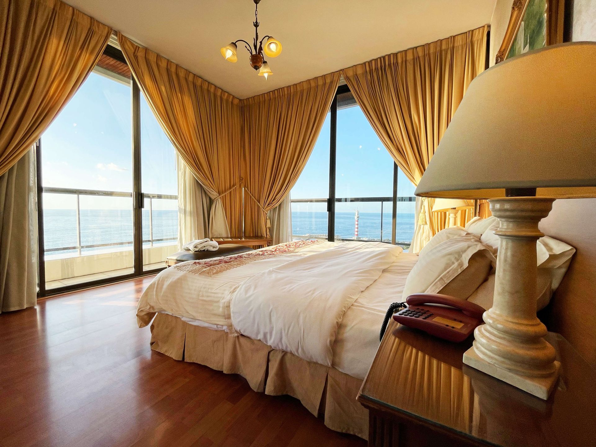 A hotel room with a large bed and a lamp