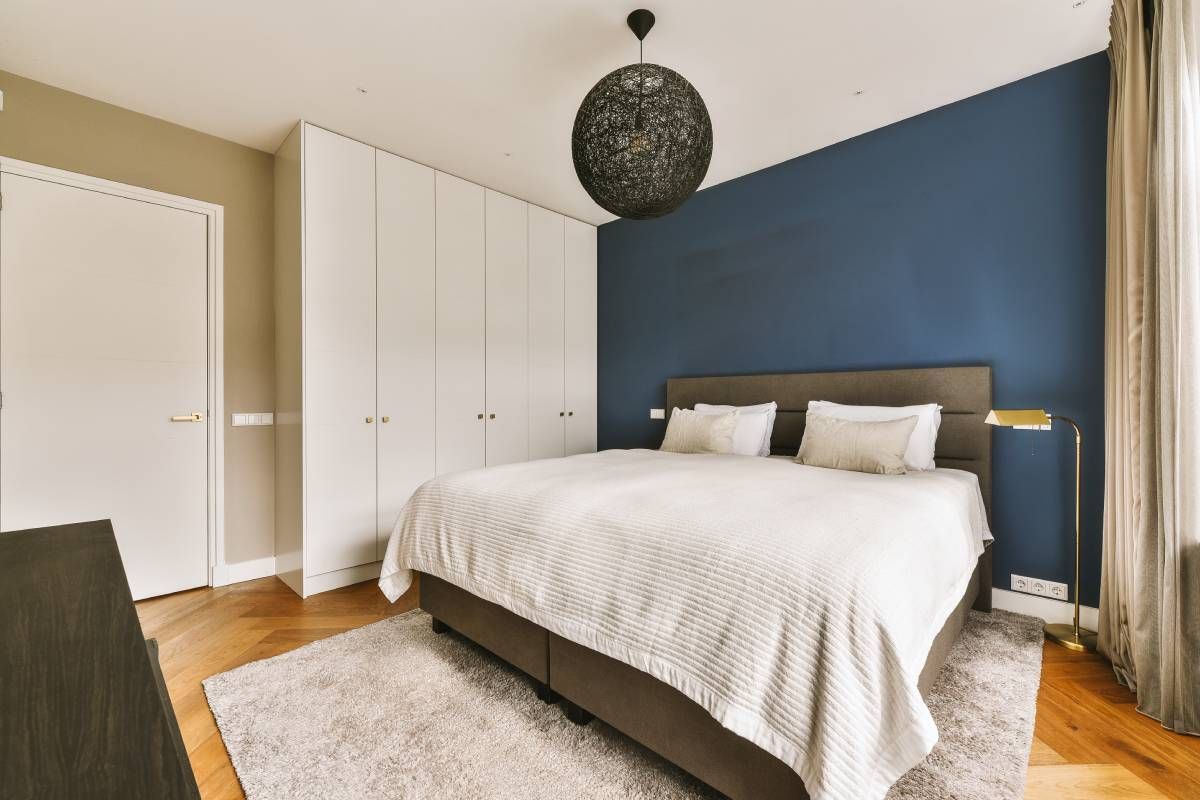 A bedroom with a blue accent wall at John Paul's Paint & Decor near Bourbonnais, Illinois