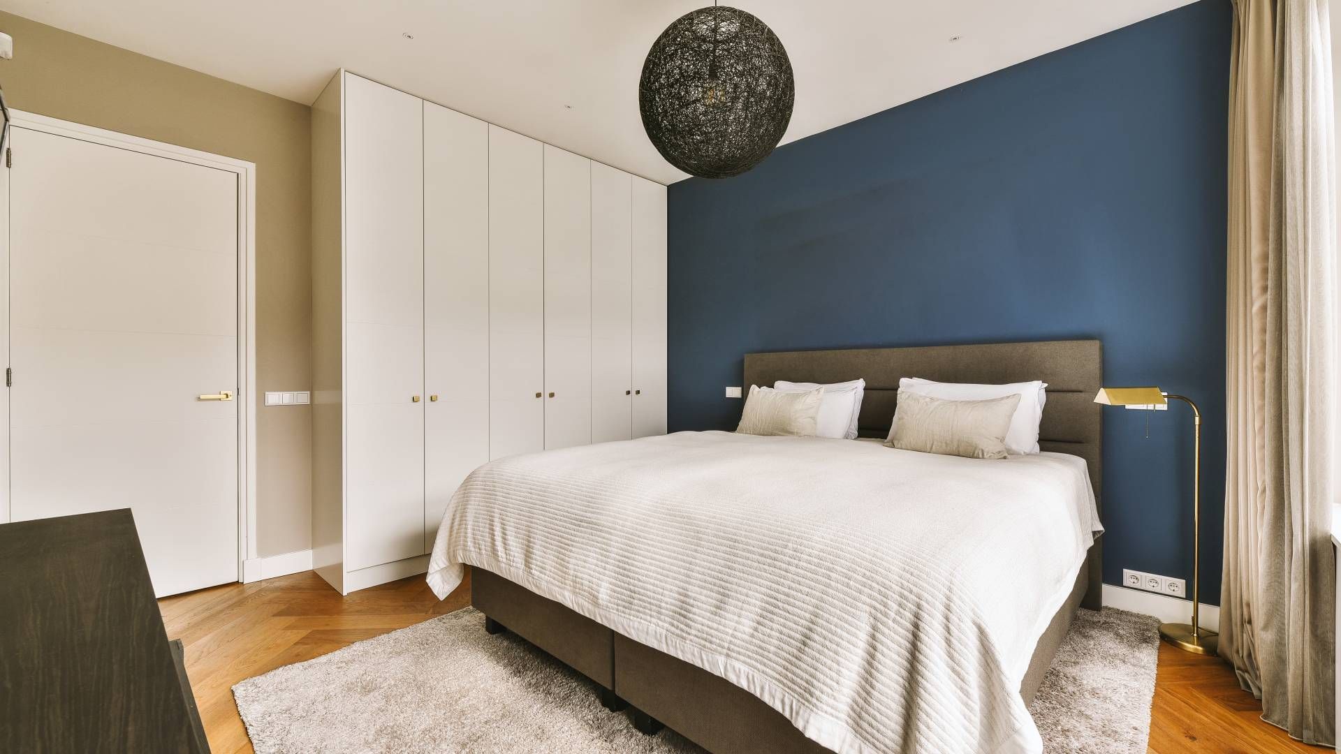 A bedroom with a blue accent wall at John Paul's Paint & Decor near Bourbonnais, Illinois