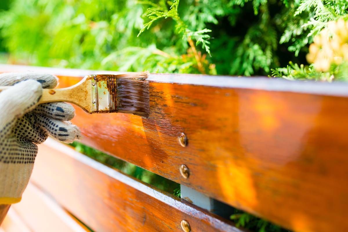 Someone staining a fence by hand with a brush near Bourbonnais, Illinois