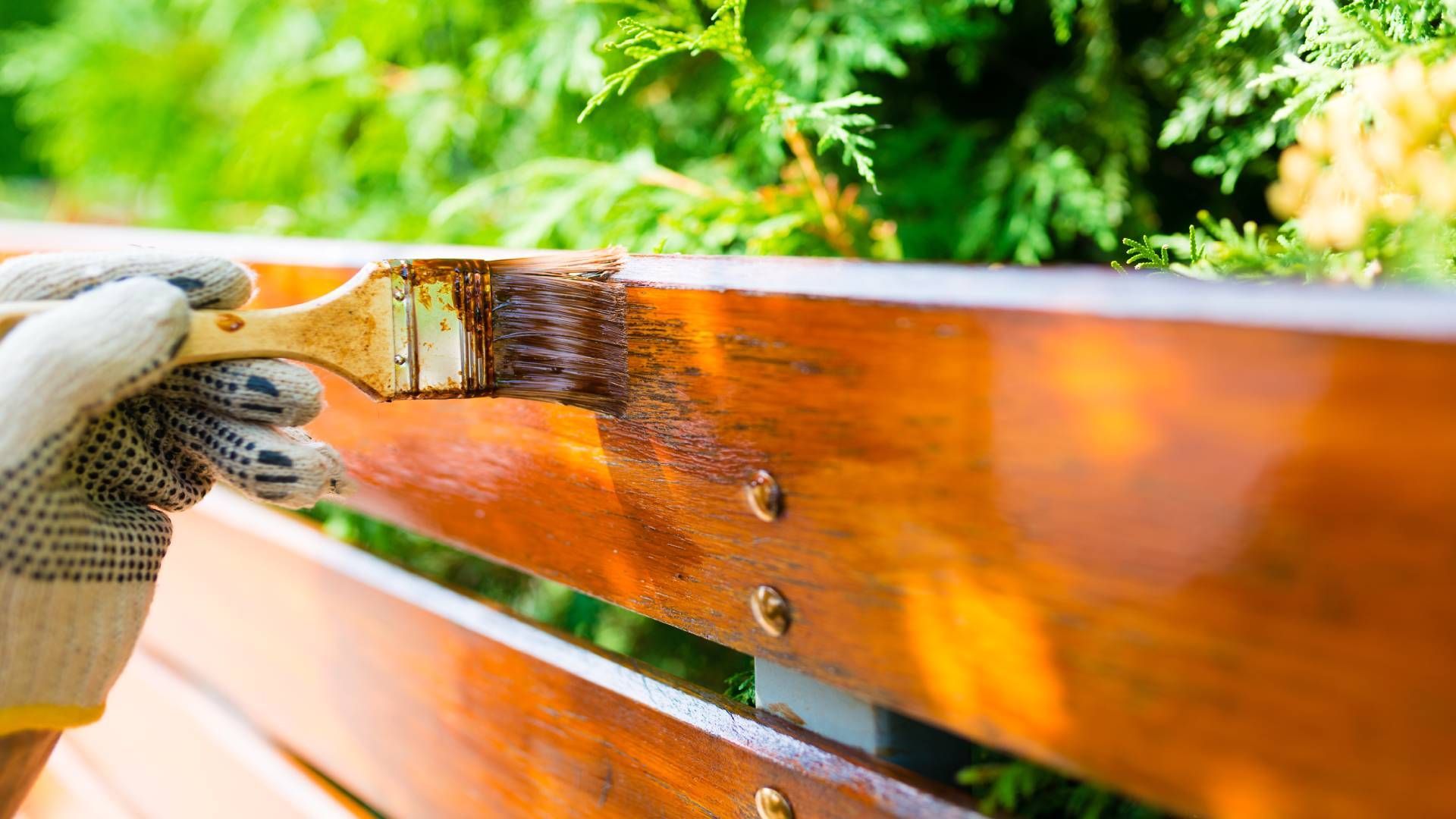 Someone staining a fence by hand with a brush near Bourbonnais, IL