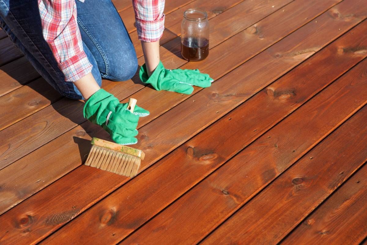 Someone applying a wood stain and finish to a deck near Bourbonnais, Illinois (IL)