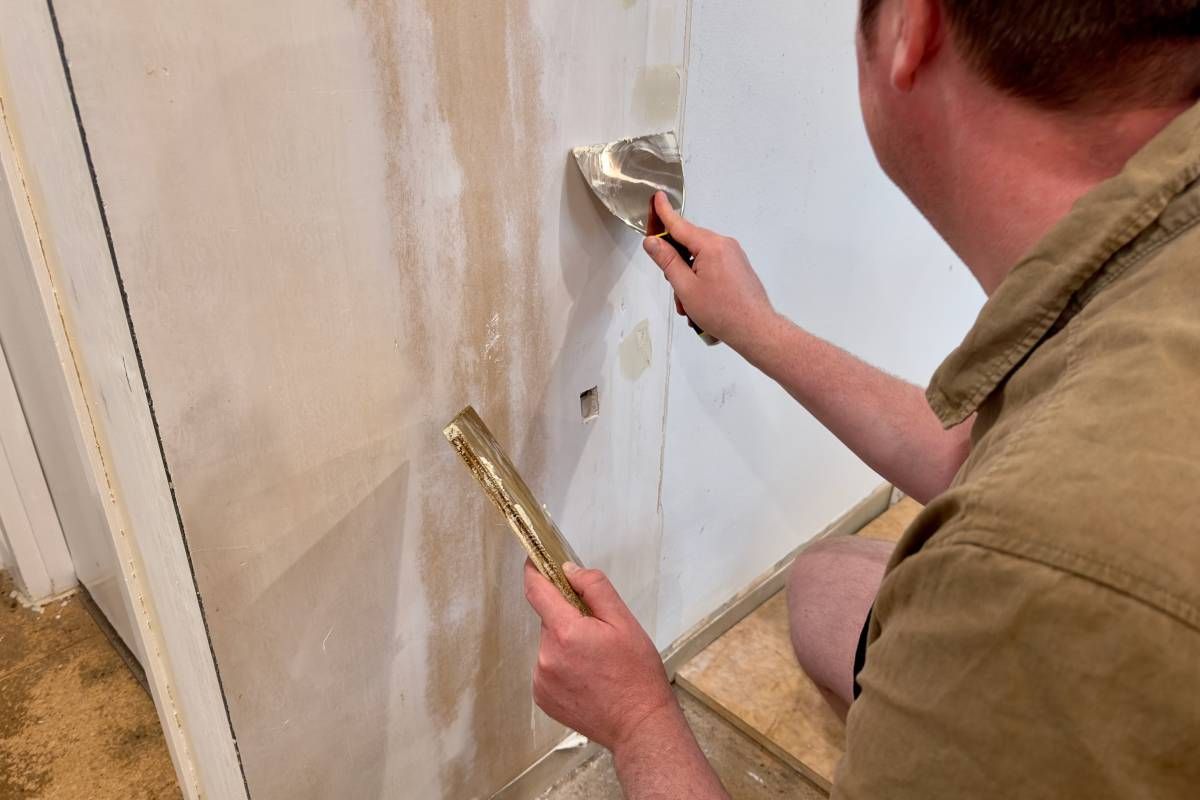 Someone preparing a wall surface for a fresh coat of paint at John Paul's Paint & Decor near Bourbonnais, Illinois 