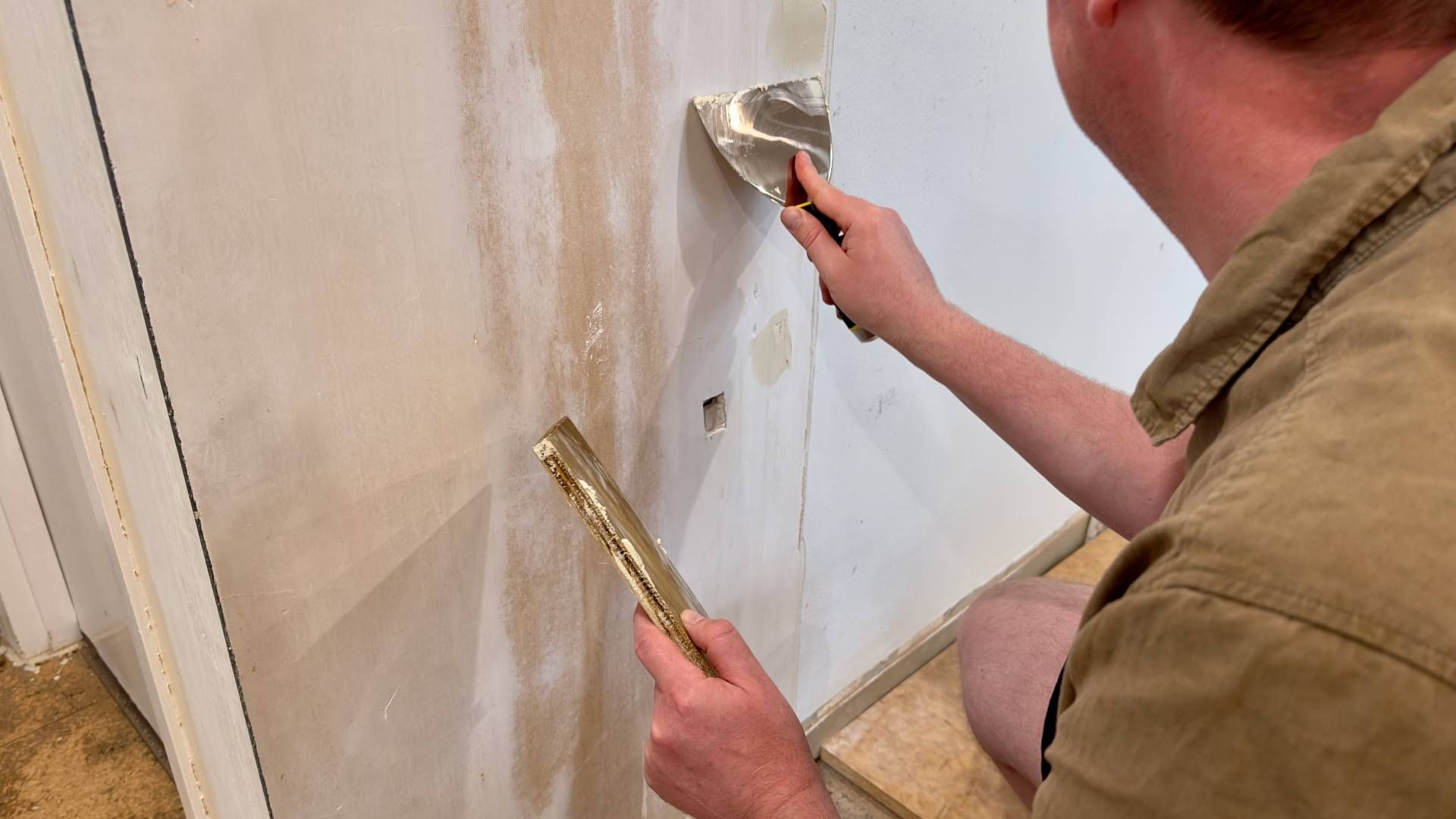 Someone preparing a wall surface for a fresh coat of paint at John Paul's Paint & Decor near Bourbon