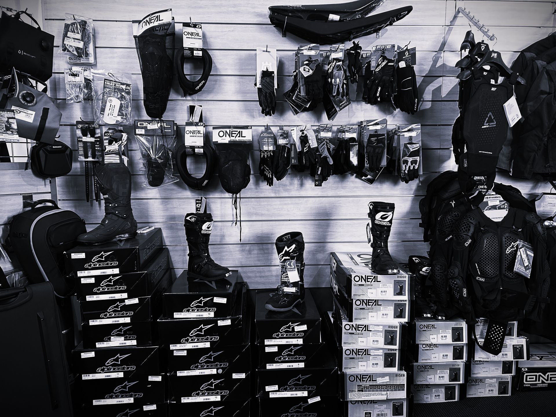 Bike shop wall display of helmets, gloves, and gear arranged on hooks and shelves