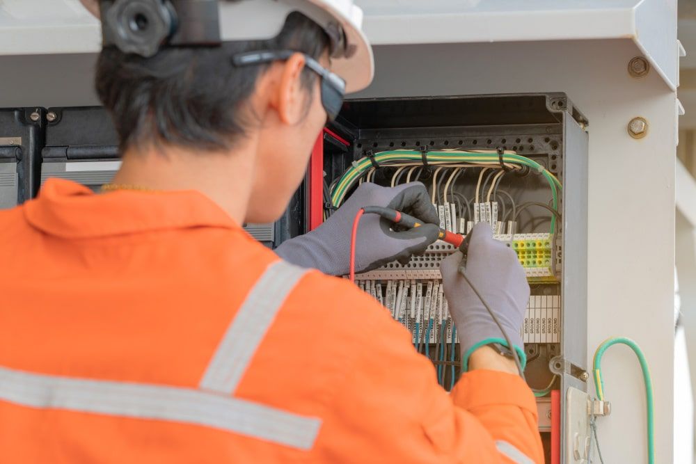 Electrician in Jumpsuit Tests Wires — McGrath Electrical & Data in South Grafton, NSW