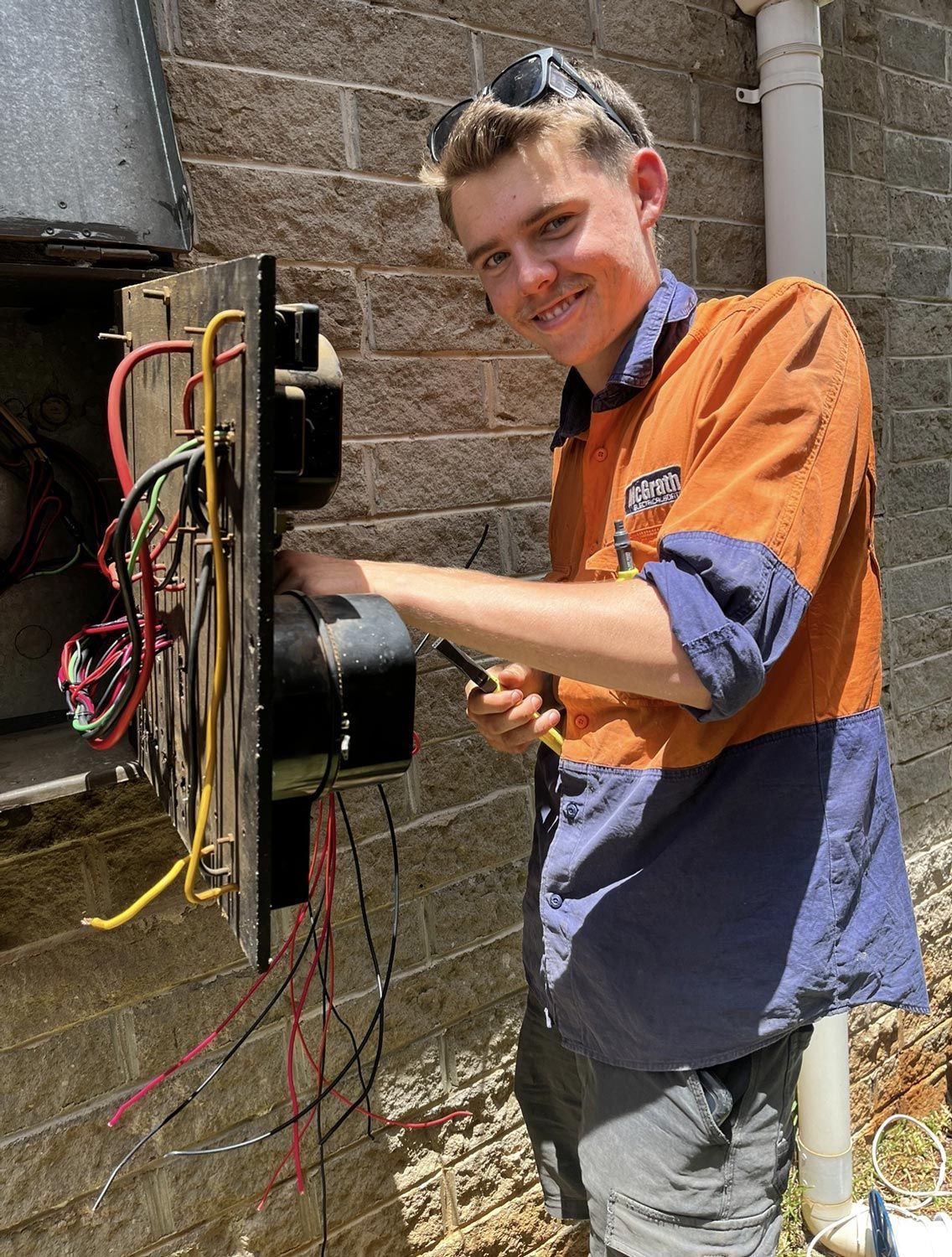 Man in Work Uniform Wiring Electrical Panel — McGrath Electrical & Data in South Grafton, NSW
