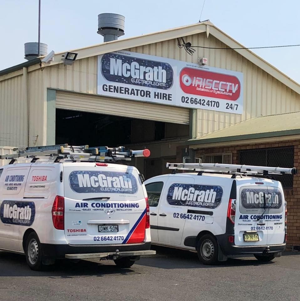 Two work vans are parked outside work garage with brand signage written all over them — McGrath Electrical & Data in South Grafton, NSW