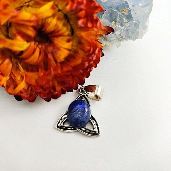 Colgante de lapislázuli con diseño de nudo celta, engastado sobre un grupo de cristales de celestita azul.