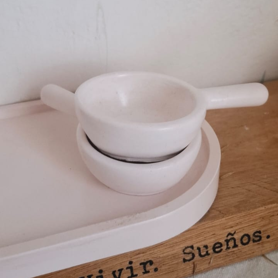 Platos de cerámica blanca con ramitas de lavanda sobre fondo de tela rosa.