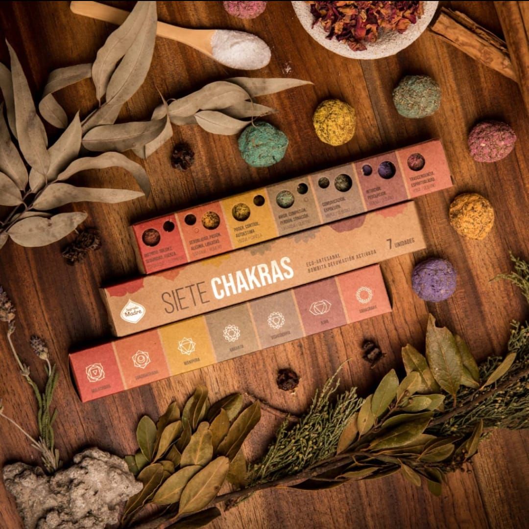 Cajas de varitas de incienso de chakras de varios colores, apiladas sobre un fondo de madera.