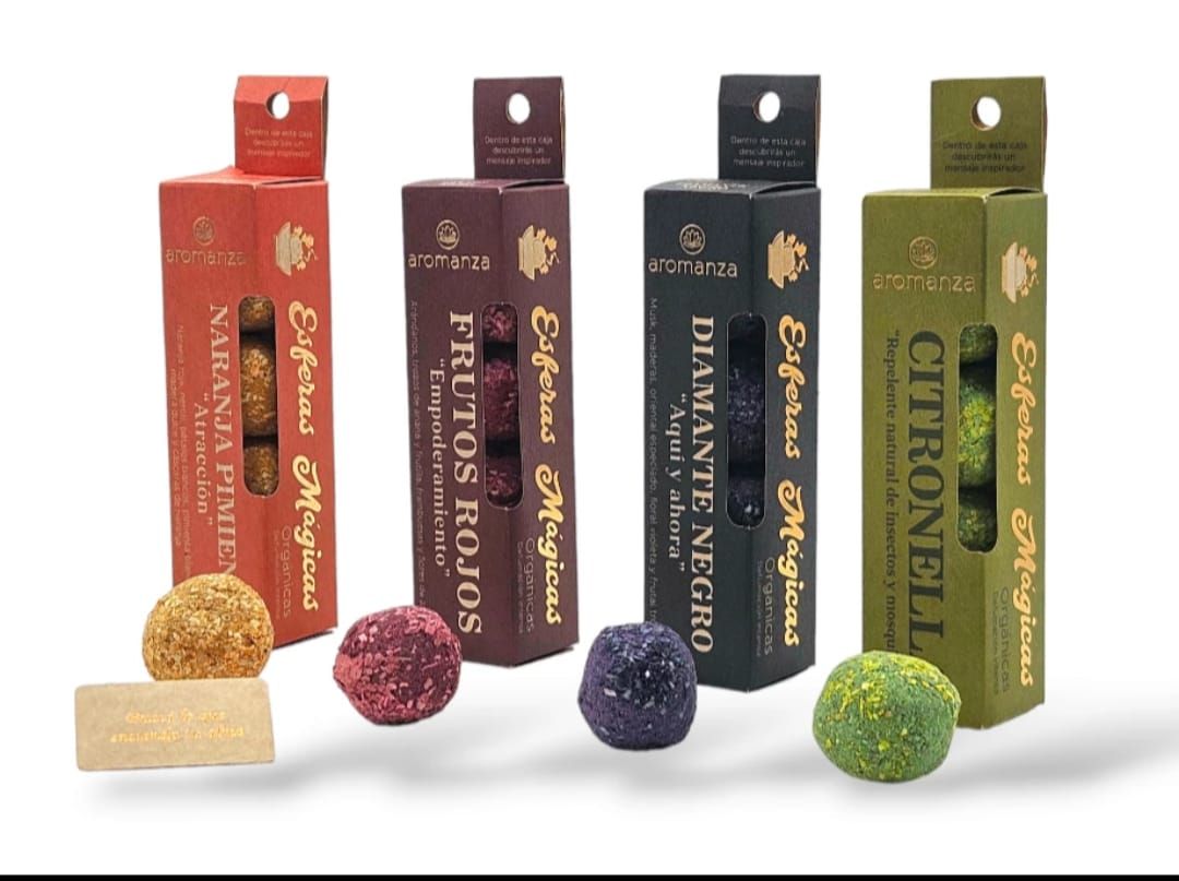 Cajas de incienso de varios colores y un cuenco de madera con hierbas sobre una superficie de madera.