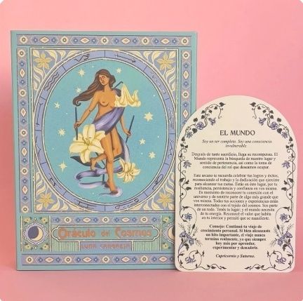 Baraja de tarot en caja con una carta. La caja muestra a una mujer enmarcada, sosteniendo lirios. La carta dice "El Mundo".