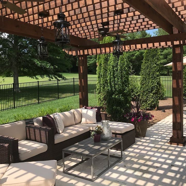 A patio with a couch and a table under a pergola