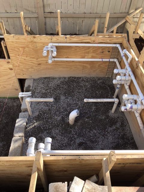 A bunch of pipes are sitting on top of a pile of gravel.