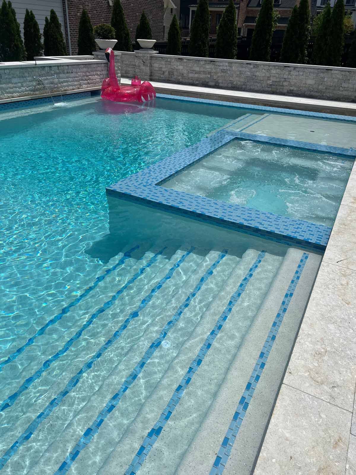 A pink flamingo float is floating in a swimming pool.