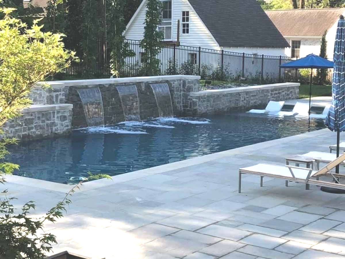 A large swimming pool with a waterfall in the middle