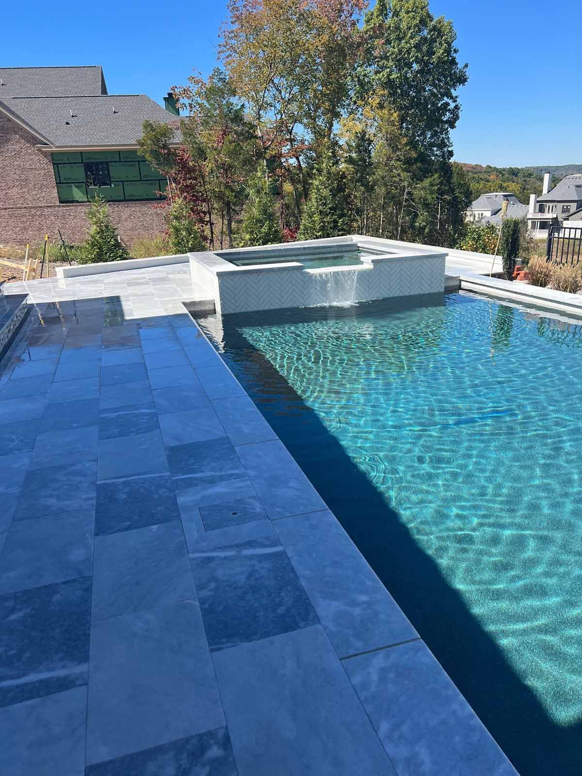 A large swimming pool with a hot tub in the middle of it.