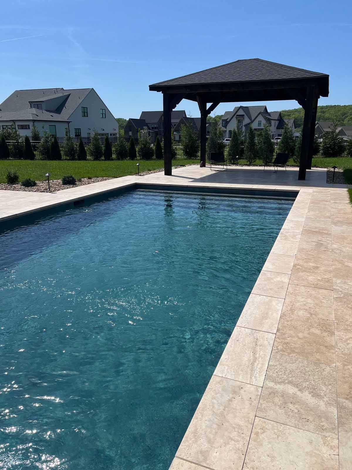 A large swimming pool with a gazebo in the background.