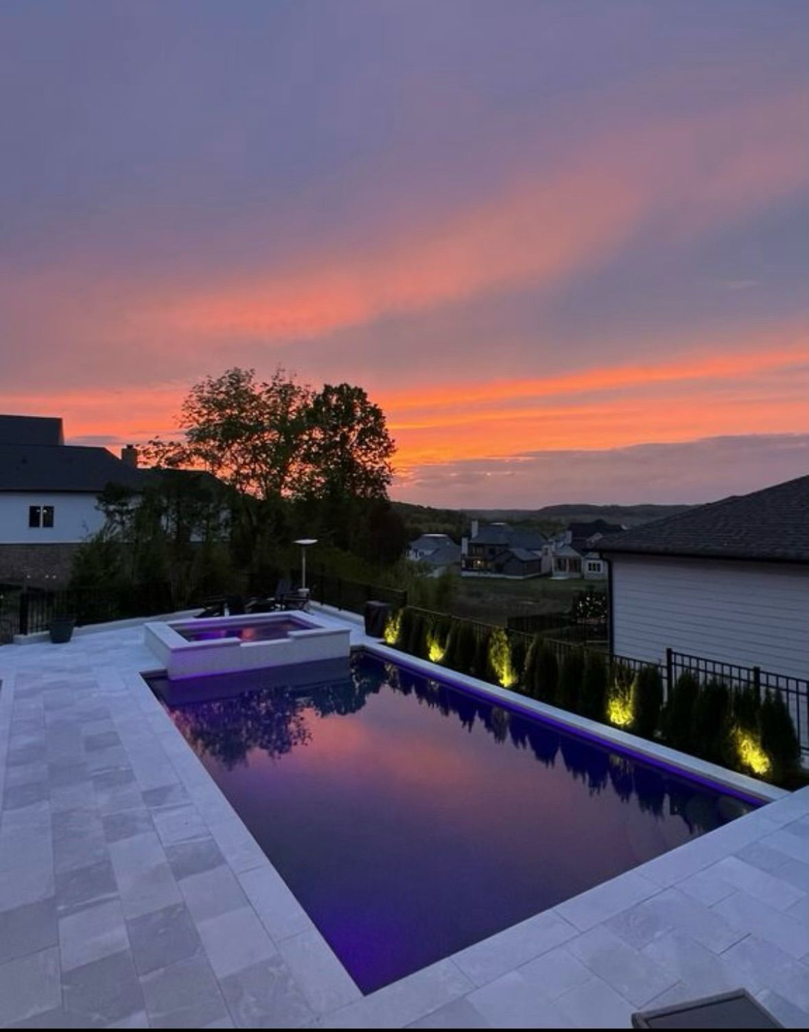 A large swimming pool with a sunset in the background