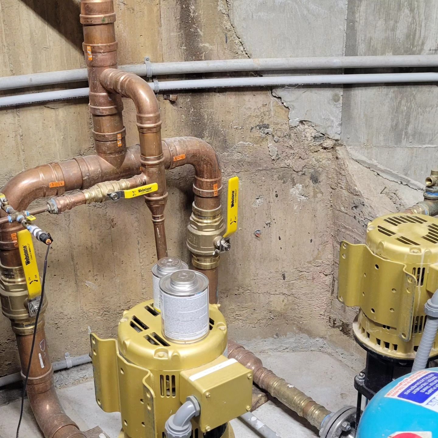 A room with a lot of copper pipes and pumps