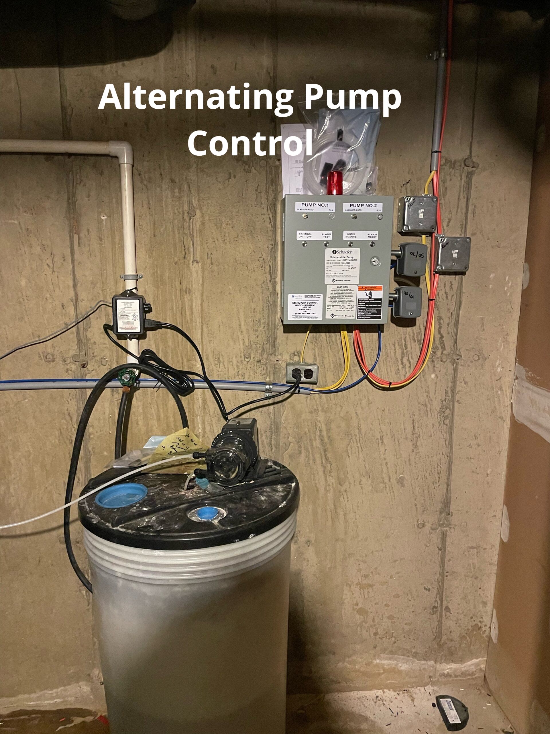 An alternating pump control is attached to a concrete wall.