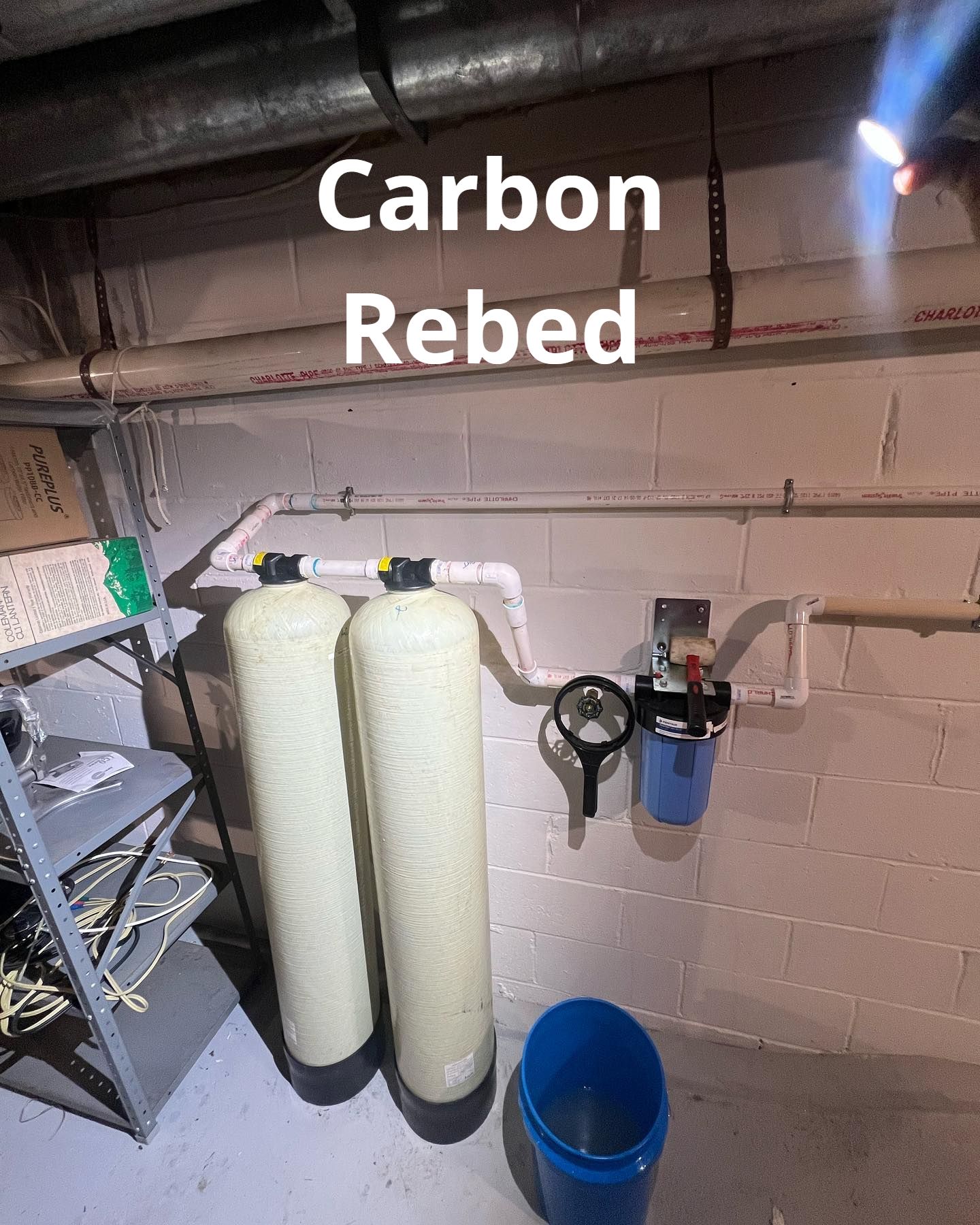 A couple of water filters sitting next to each other in a basement.