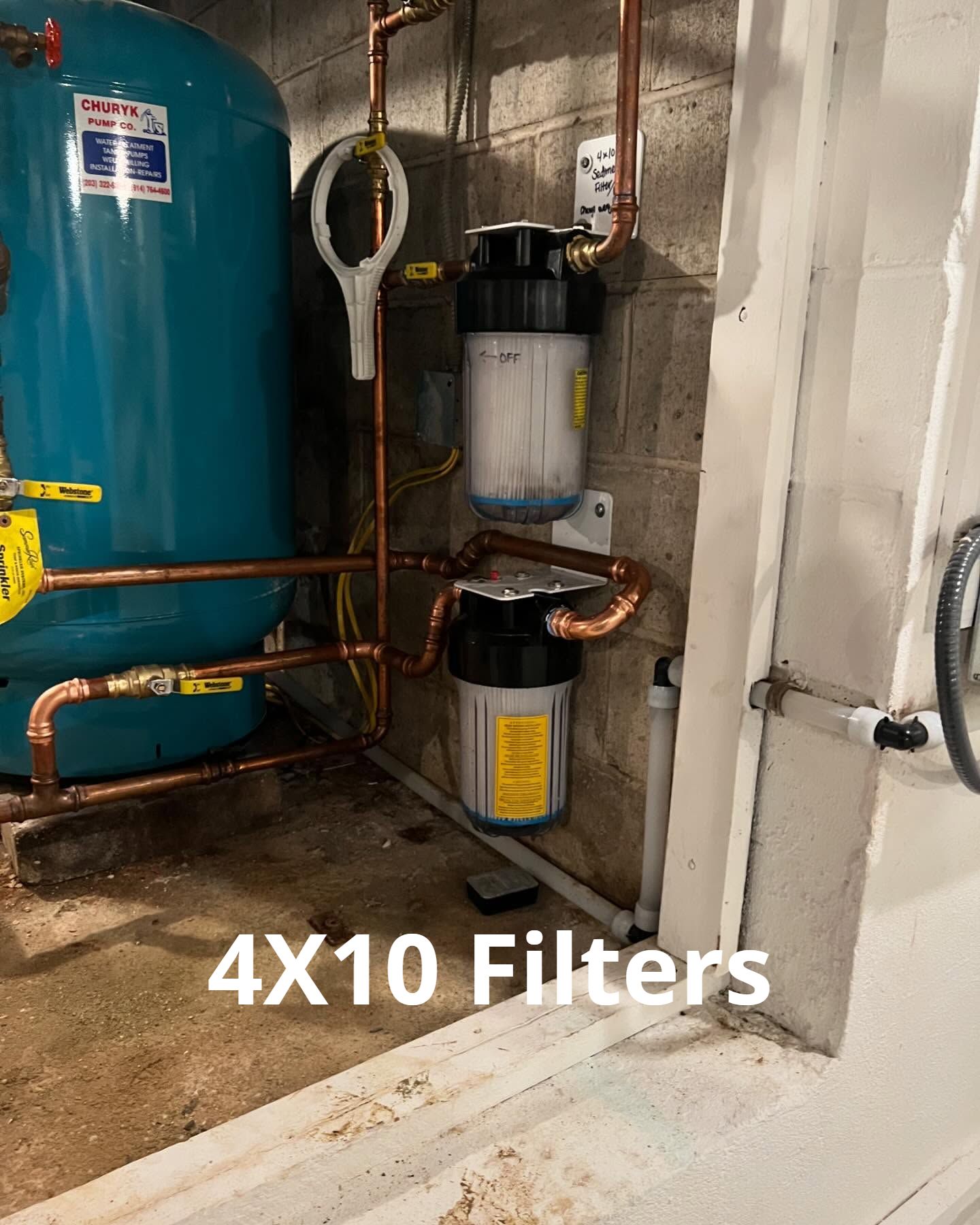 A water tank with a filter attached to it in a basement.